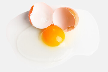 Broken egg with shell spilled on a light background