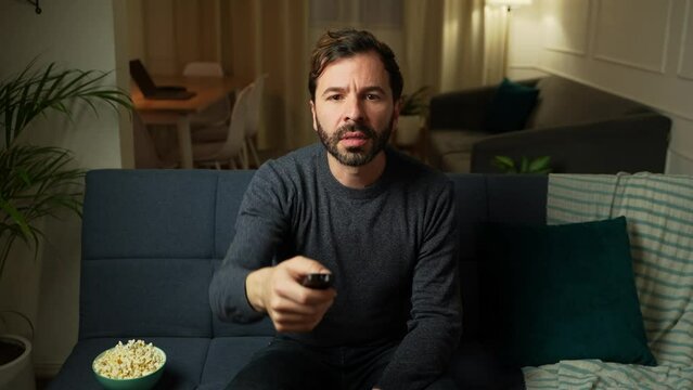 Man surfing through different channels on TV until finding something interesting