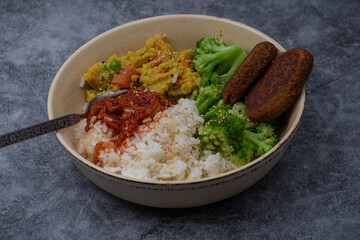 Vegan cutlets made of seitan. along with rice, kimchi, side veggies. Vegan bowl.