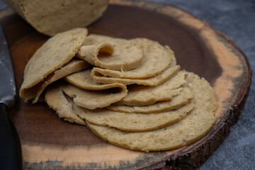 Vegan ham made in ham mold, sliced, wooden board. Mock vegan meat as plant based alternative to meat.