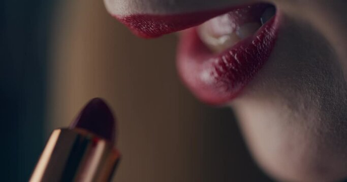 Closeup of trendy woman applying red lipstick