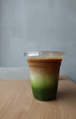 close up of green tea matcha milk espresso in plastic cup in brown white and green colour Layered matcha drink. 