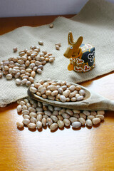 Carioca beans on the wooden spoon with a caracther of brazilian folklore.