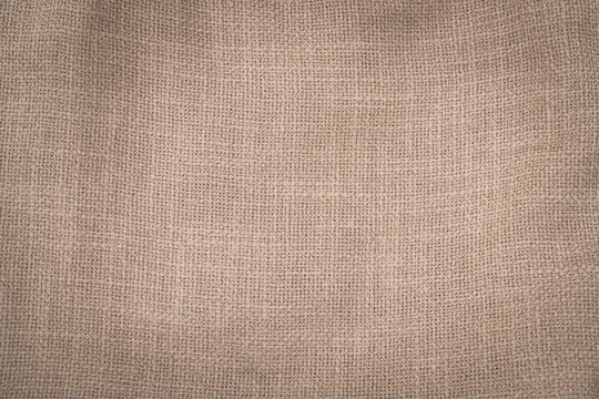 Hessian sackcloth woven jute burlap fabric cloth textile texture pattern background in brown beige aged color
