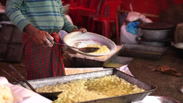 Art of making Rasgulla, a delightful Indian dessert made from milk solids, deep-fried to golden perfection and soaked in fragrant sugar syrup. Vibrant, aromatic, tempting. A feast for the senses
