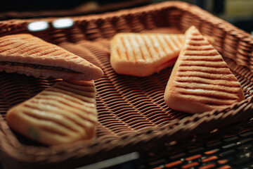 Freshly baked cheese and meat sandwiches in a wicker basket