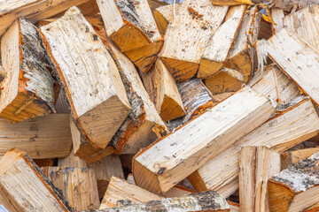 A close-up top view of a pile of chopped birch firewood. 
