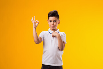 Smiling child boy showing ok gesture. Positive emotions concept