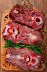 raw steak, calf's neck on the bone, fresh meat, on the cutting board, top view, no people,