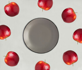 Empty gray plate for text and red apples on the gray background. Top view. Copy space.