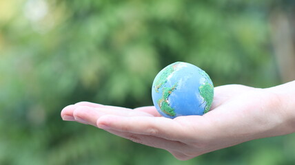 Environment Earth Day In the hands holding green earth on Bokeh green Background, Saving environment, and environmentally sustainable. Save Earth. Concept of the Environment World Earth Day