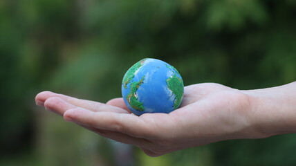 Environment Earth Day In the hands holding green earth on Bokeh green Background, Saving environment, and environmentally sustainable. Save Earth. Concept of the Environment World Earth Day