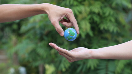 Environment Earth Day In the hands holding green earth on Bokeh green Background, Saving environment, and environmentally sustainable. Save Earth. Concept of the Environment World Earth Day