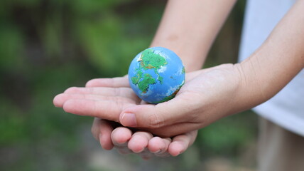 Environment Earth Day In the hands holding green earth on Bokeh green Background, Saving environment, and environmentally sustainable. Save Earth. Concept of the Environment World Earth Day