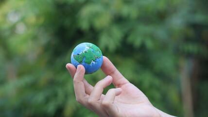 Environment Earth Day In the hands holding green earth on Bokeh green Background, Saving environment, and environmentally sustainable. Save Earth. Concept of the Environment World Earth Day