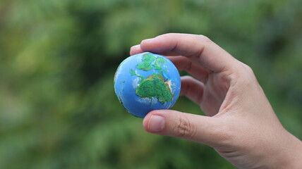 Environment Earth Day In the hands holding green earth on Bokeh green Background, Saving environment, and environmentally sustainable. Save Earth. Concept of the Environment World Earth Day