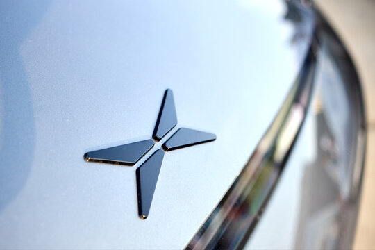 Berlin, Germany - August 20, 2022: Car Detail XPeng Motors electric car logo. X Peng Xiaopeng is a Chinese EV company. Closeup selective focus shot.