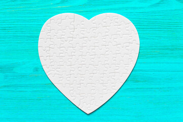 White Heart-Shaped Puzzle on a Blue Wooden Background