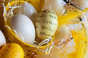 Ostereier zu Ostern in einem gelben Nest als Dekoration mit Aufschrift, Frohe Ostern