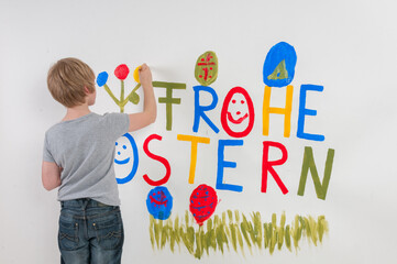 Ein Junge mit der Botschaft Frohe Ostern auf eine Wand gemalt - 744697533
