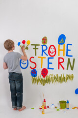Ein Junge mit der Botschaft Frohe Ostern auf eine Wand gemalt - 744697536