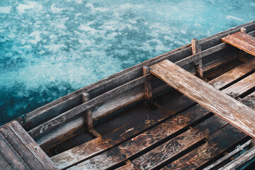Close up of an old wooden rowboat on the frozen lake.