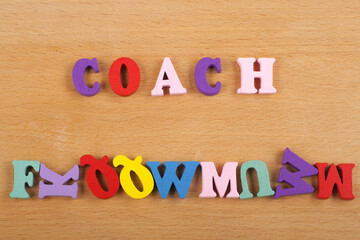 COACH word on wooden background composed from colorful abc alphabet block wooden letters, copy space for ad text. Learning english concept.