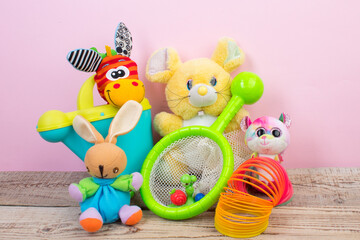 Collection of colorful toys on pink background.