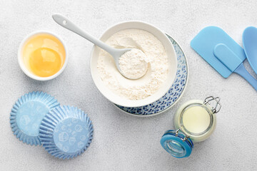 Baking ingredients: flour, eggs, yolk, on a white table.