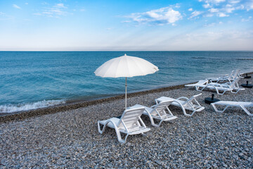 Idyllic morning on the beach: sun loungers and sun umbrellas in the resort