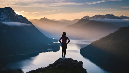 Silhouette of woman on mountain peak at dawn, symbolizing success, empowerment, solitude, and triumph over challenges - obrazy, fototapety, plakaty