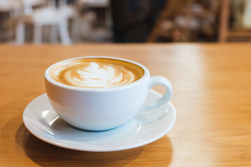 Hot coffee latte in cup mug on the table in cafe