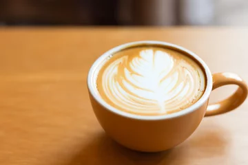 Schilderijen op glas Hot coffee latte in cup mug on the table in cafe © Rachanon