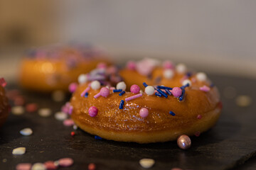closeup of donuts with colorful sprinkles on blackboard