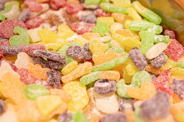 a heap of sweet marmalade scattered. multi-colored marmalade covered with sugar