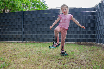 The child helps with scarifying the lawn.