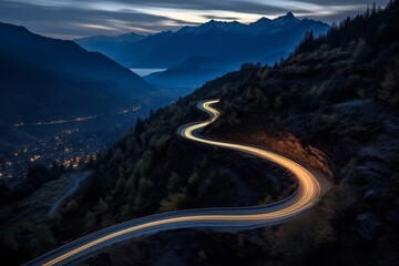 Aerial panoramic view of curvy mountain road with trailing lights at night. Winding road with car speed lights. Beautiful countryside landscape