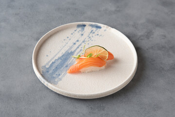 Salmon nighiri on ceramic plate and gray bottom 