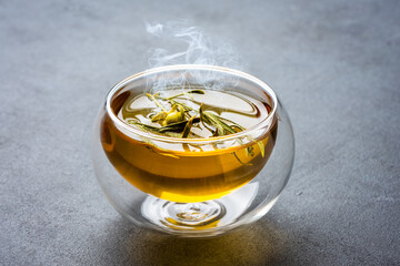 Glass of tea or herbal tea on black stone background