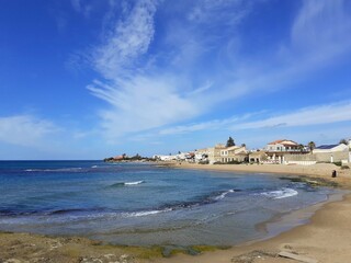 Panorama di Punta Secca, un borgo adagiato sulla spiaggia in riva al mare.