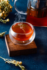 Glass of tea or herbal tea on black stone background