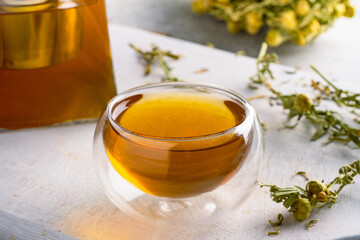 Glass of tea or herbal tea on white stone background
