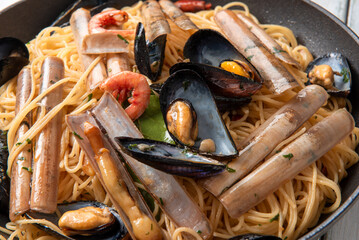 Padella con deliziosi spaghetti con frutti di mare misti, pasta italiana, cibo mediterraneo