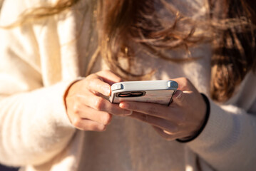 Closeup of a Chinese woman hand manipulating her smartphone. Girl using phone