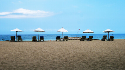 Parasols and chairs lining an empty beach