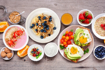 Healthy breakfast or brunch table scene on a wood background. Above view. Avocado toast, smoothie...