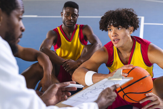 Basketball coach discussing strategy with players on court