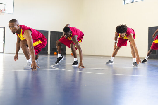 Diverse basketball players practice in an indoor court - Powered by Adobe