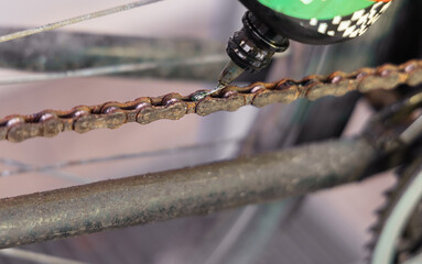 Putting oil on a rusty bicycle chain - 744750584