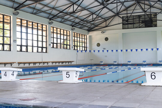 An indoor swimming pool awaits competitors, with copy space